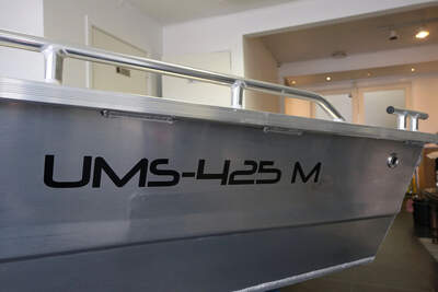 Närbild av UMS 425M:s skrov, reling och modellmärkning.