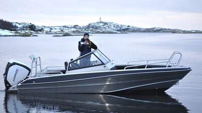 UMS Tuna 585 DC fotograferad från sidan i lugnt vatten.