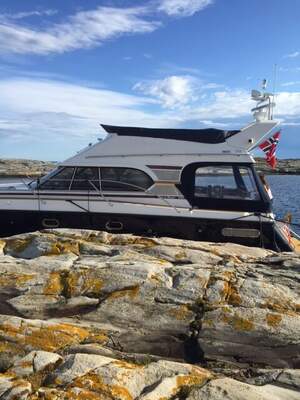 Nord West 390 Flybridge från sidan, förtöjd vid klippor.