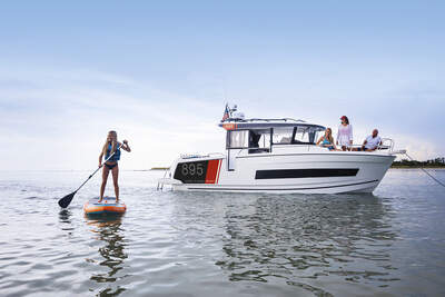 Jeanneau Merry Fisher 895 Sport vid stillaliggande, med paddlare intill båten.