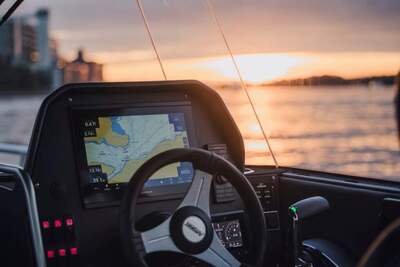 Närbild av förarplatsen med Garmin-navigator och reglage.