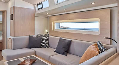 Salong och sittgrupp i ljus ekfinish ombord på Oceanis Yacht 60.