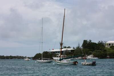 En International One Design-segelbåt på Bermuda tillsammans med en bermudiansk arbetsbåt. Foto: Seán Pòl Ó Creachmhaoil