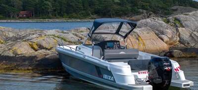 IBIZA 801 Sport CAB nära land med kapell och utombordsmotor synliga.